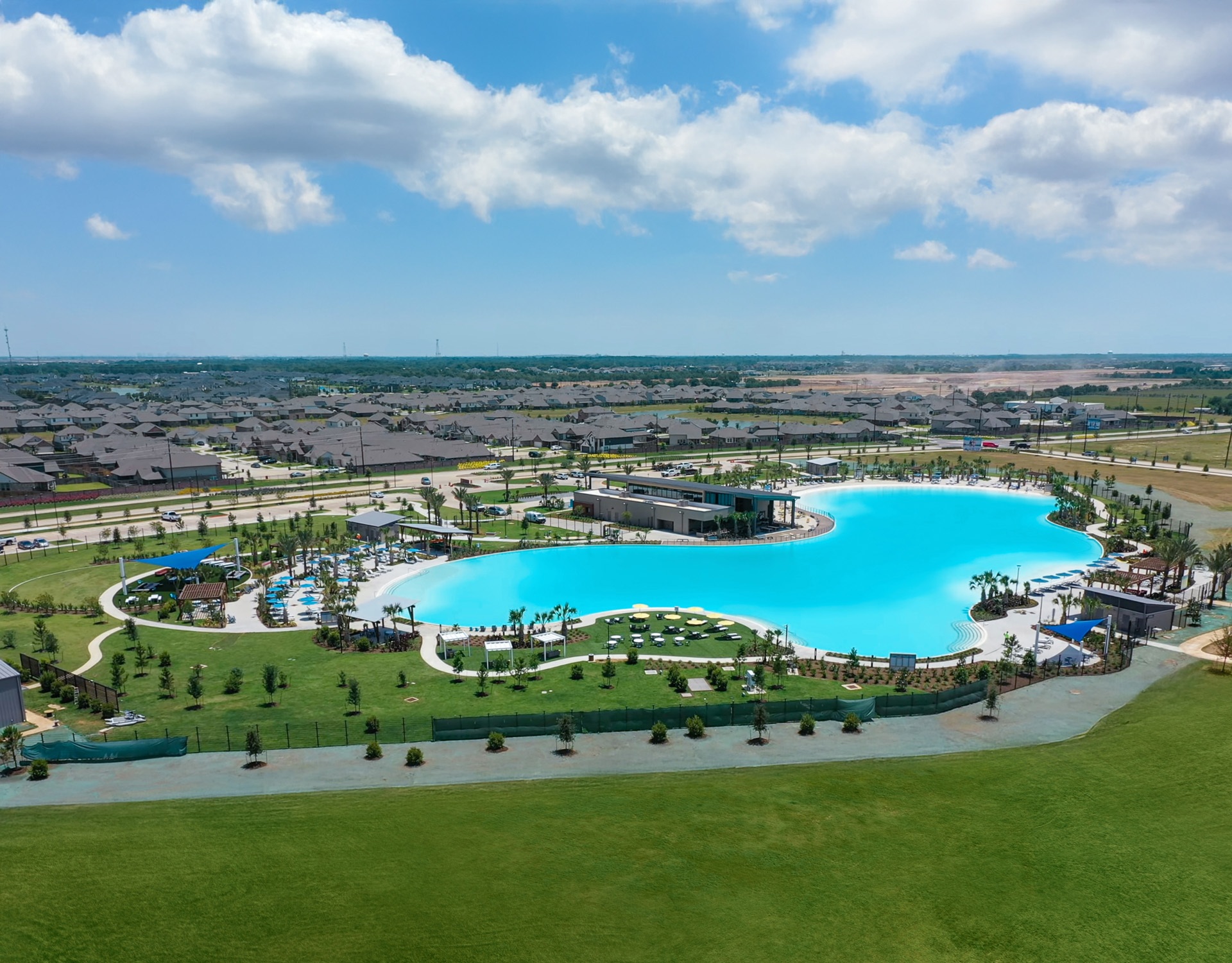 Crystal Lagoons lagoon at The Sol Club in Sunterra, with white-sand beach along the Sunterra lagoon shoreline, Katy, Texas
