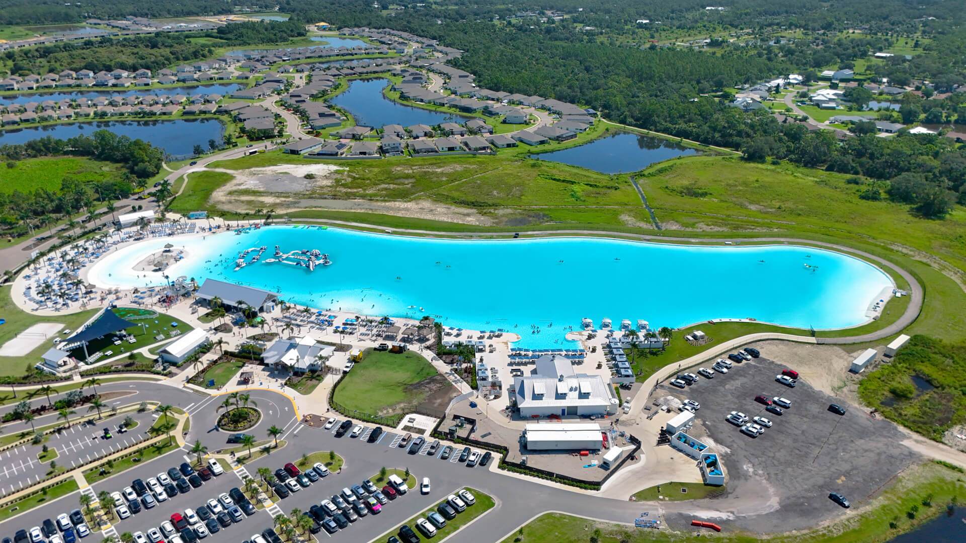 Aerial view of the turquoise Brightwater lagoon surrounded by green landscaping in Florida