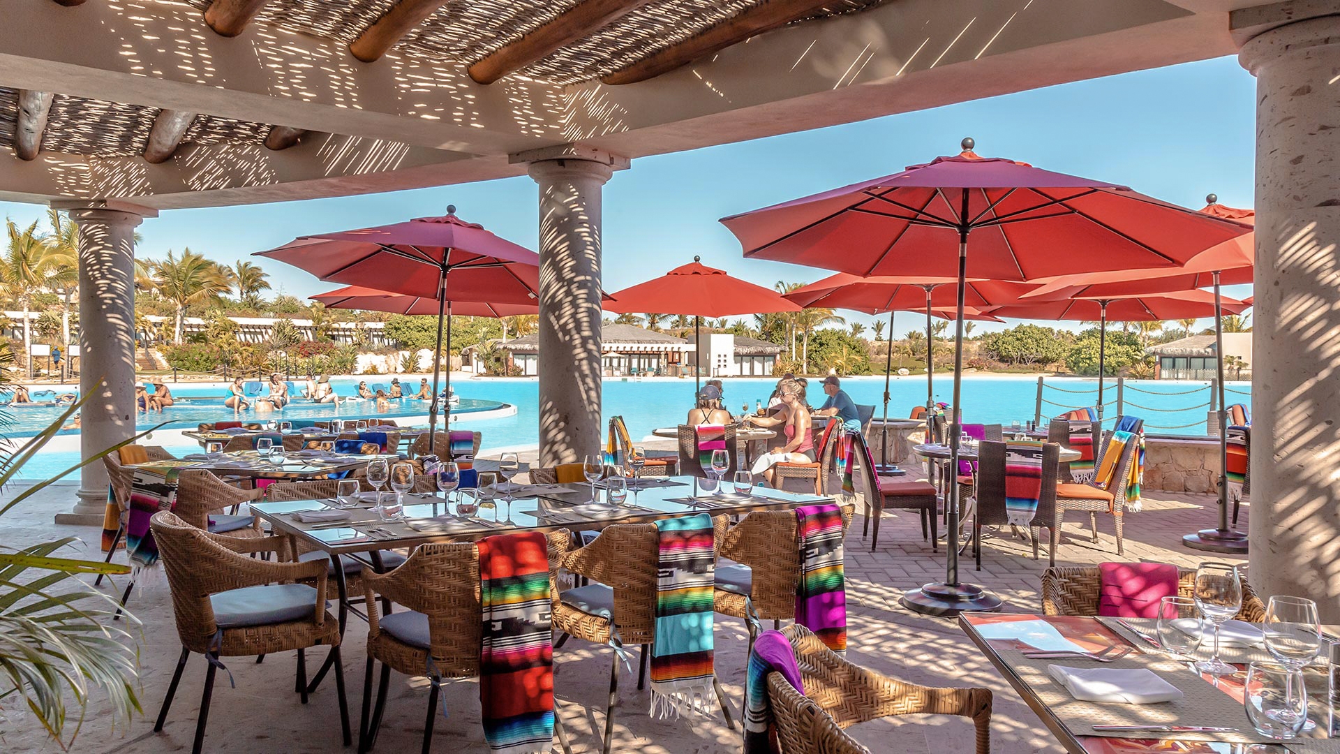 Lagoon-front restaurant terrace with red umbrellas for food and beverage offerings