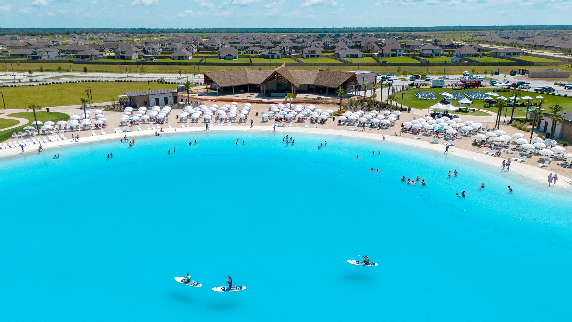 Aerial view of Angel Lagoon in Texas with paddleboarders and a lagoon-front beach club