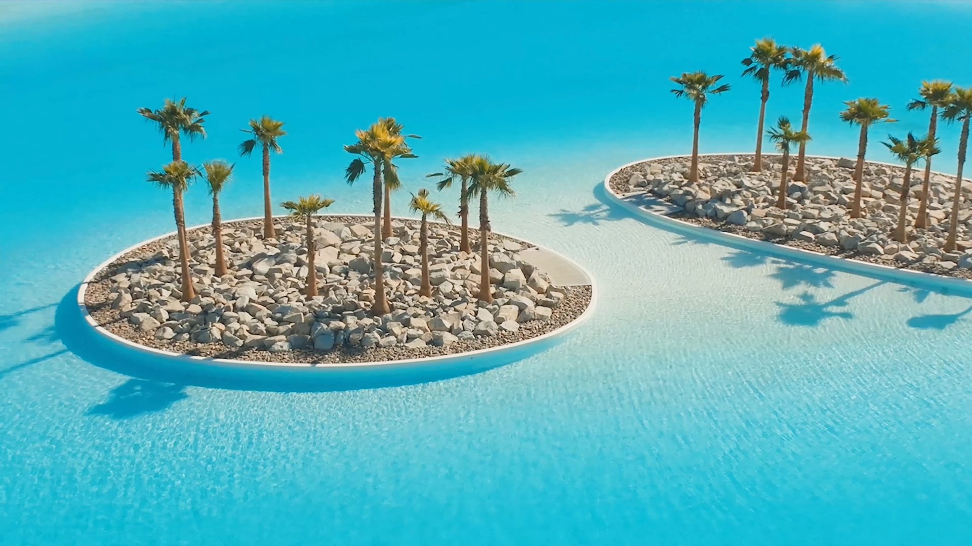 Turquoise Crystal Lagoons amenity with palm islands at Cotino, a Storyliving by Disney community, California